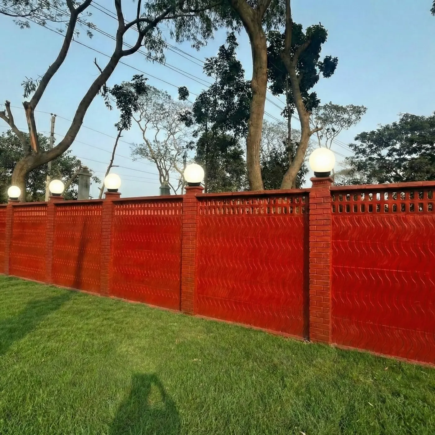 Red wave-texture precast boundary wall with lamp posts